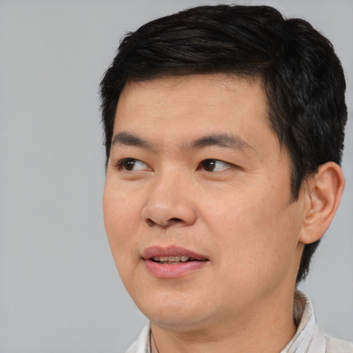 Joyful asian adult male with short  black hair and brown eyes