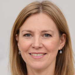 Joyful white adult female with long  brown hair and brown eyes