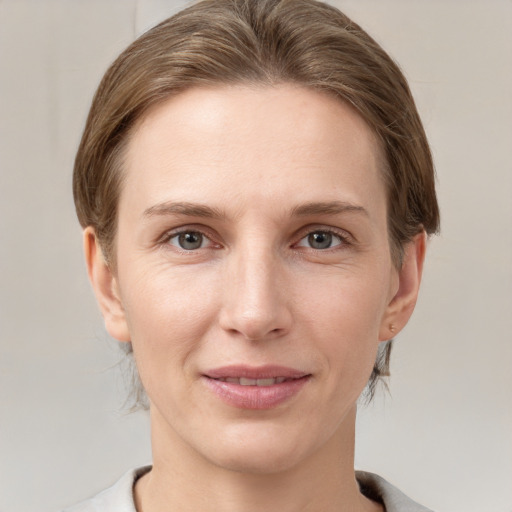 Joyful white young-adult female with short  brown hair and grey eyes