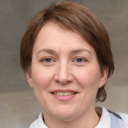 Joyful white adult female with medium  brown hair and grey eyes