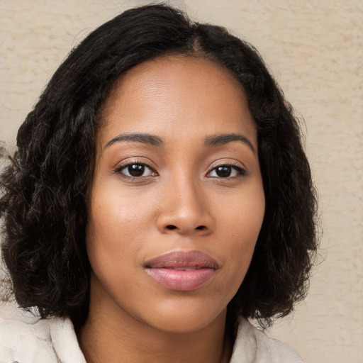 Joyful black young-adult female with medium  brown hair and brown eyes