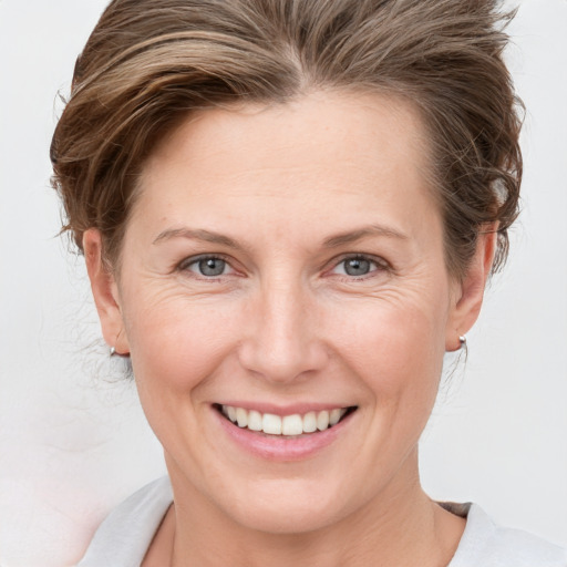 Joyful white adult female with medium  brown hair and grey eyes