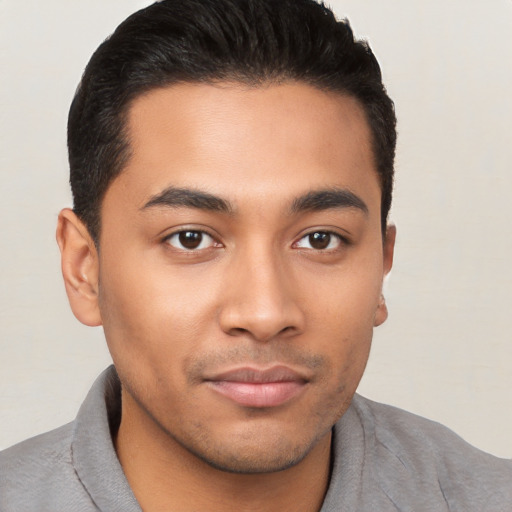 Joyful latino young-adult male with short  brown hair and brown eyes