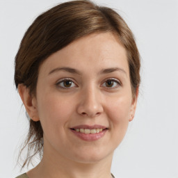 Joyful white young-adult female with medium  brown hair and grey eyes