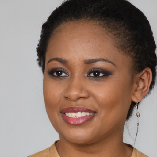 Joyful black young-adult female with long  brown hair and brown eyes