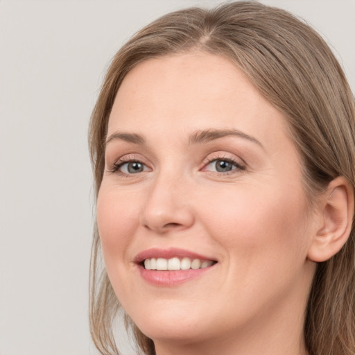 Joyful white young-adult female with long  brown hair and grey eyes