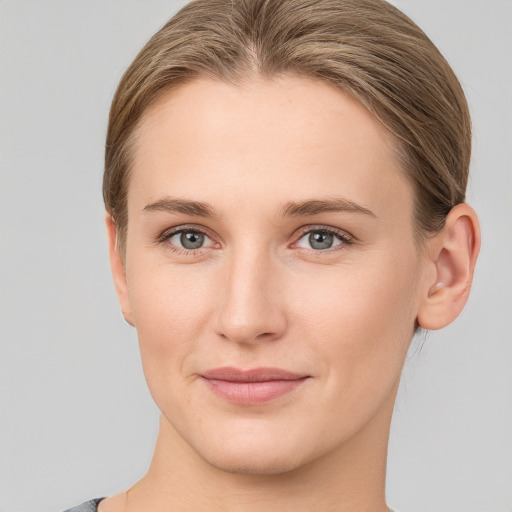 Joyful white young-adult female with medium  brown hair and grey eyes