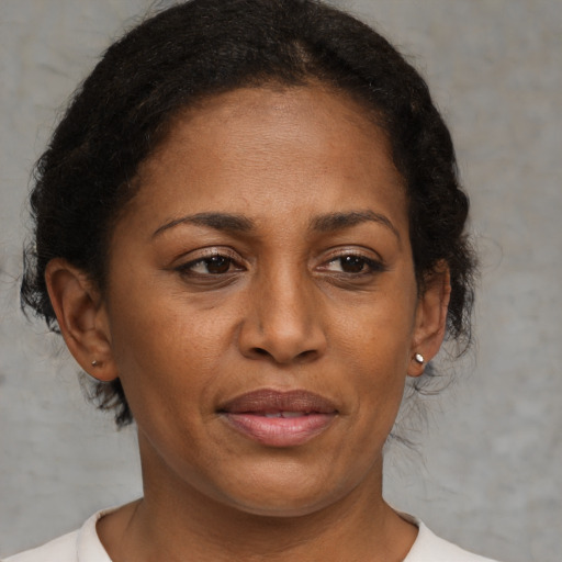 Joyful black adult female with medium  brown hair and brown eyes