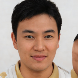 Joyful asian young-adult male with short  brown hair and brown eyes