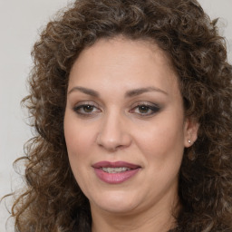 Joyful white adult female with long  brown hair and brown eyes