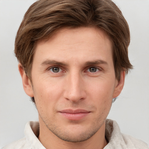 Joyful white young-adult male with short  brown hair and grey eyes