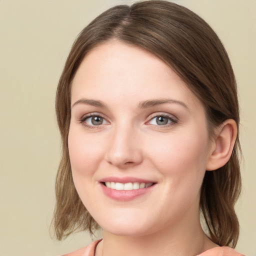 Joyful white young-adult female with medium  brown hair and green eyes