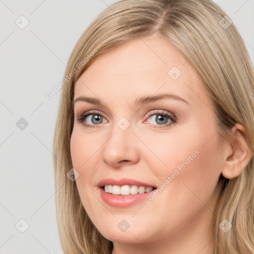 Joyful white young-adult female with long  brown hair and blue eyes