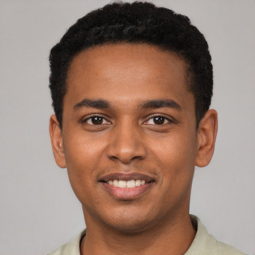 Joyful black young-adult male with short  black hair and brown eyes