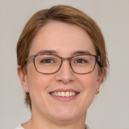 Joyful white adult female with medium  brown hair and green eyes