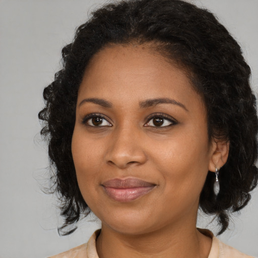 Joyful black young-adult female with medium  brown hair and brown eyes