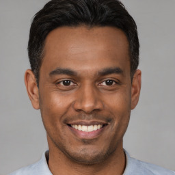 Joyful latino young-adult male with short  black hair and brown eyes