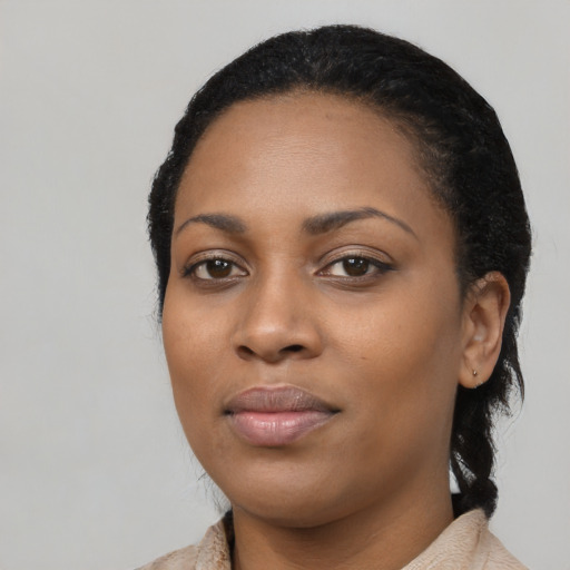 Joyful black young-adult female with long  black hair and brown eyes