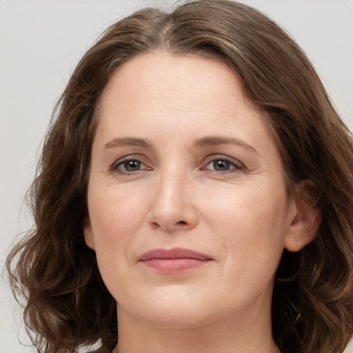 Joyful white young-adult female with medium  brown hair and green eyes