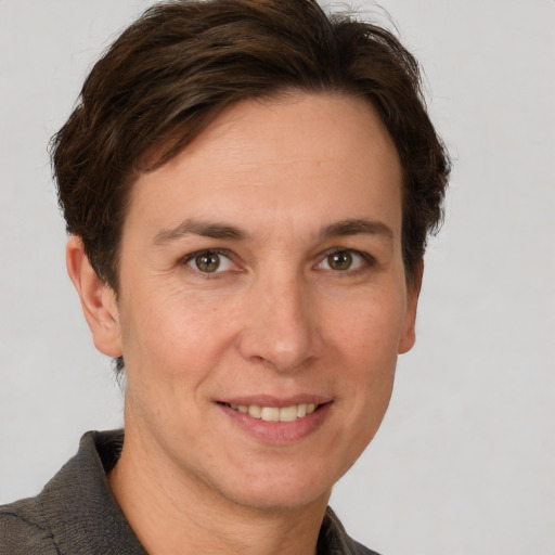 Joyful white adult female with short  brown hair and grey eyes