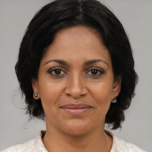 Joyful black adult female with medium  brown hair and brown eyes