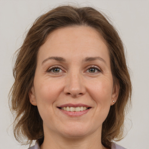 Joyful white adult female with medium  brown hair and grey eyes