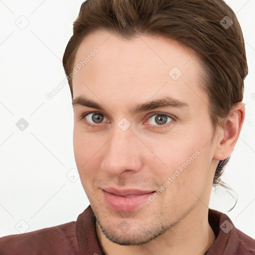 Joyful white young-adult male with short  brown hair and grey eyes