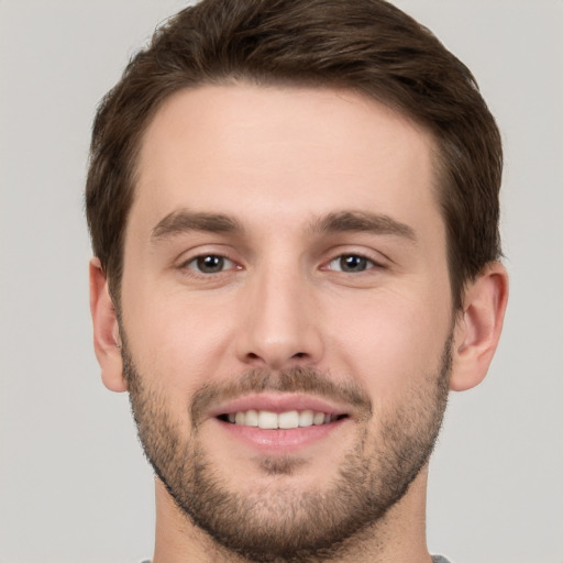 Joyful white young-adult male with short  brown hair and brown eyes