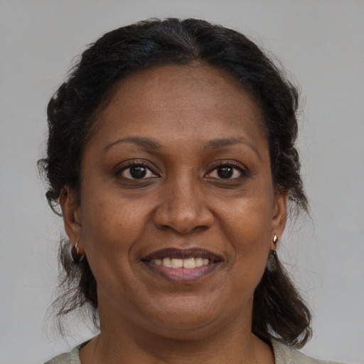 Joyful black adult female with medium  brown hair and brown eyes