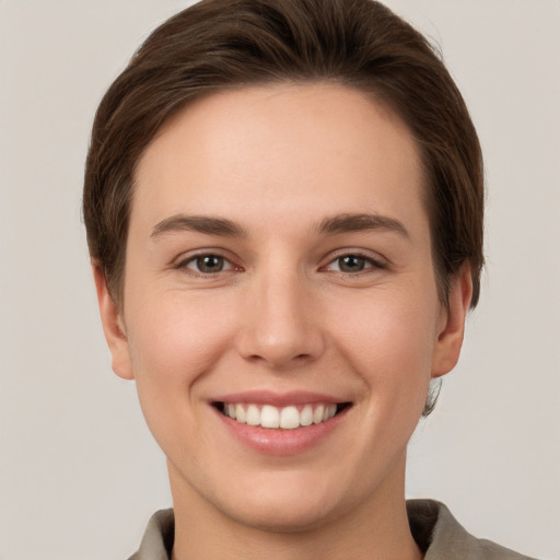 Joyful white young-adult female with short  brown hair and grey eyes