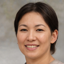 Joyful asian adult female with medium  brown hair and brown eyes