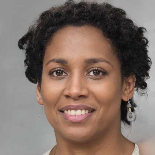 Joyful black young-adult female with short  brown hair and brown eyes