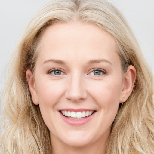 Joyful white young-adult female with long  brown hair and blue eyes