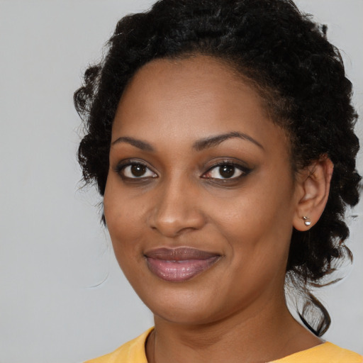 Joyful black young-adult female with medium  black hair and brown eyes
