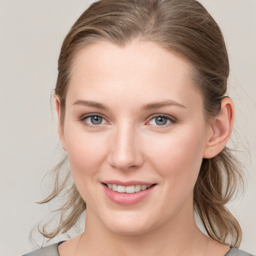 Joyful white young-adult female with medium  brown hair and grey eyes