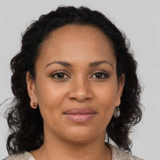 Joyful black young-adult female with long  brown hair and brown eyes