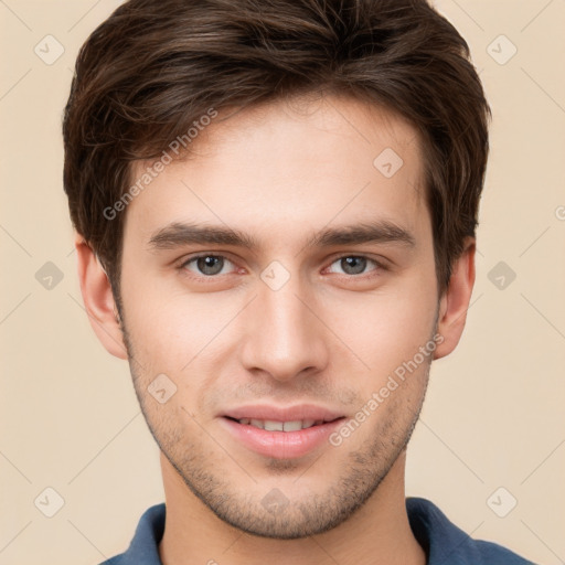 Joyful white young-adult male with short  brown hair and grey eyes