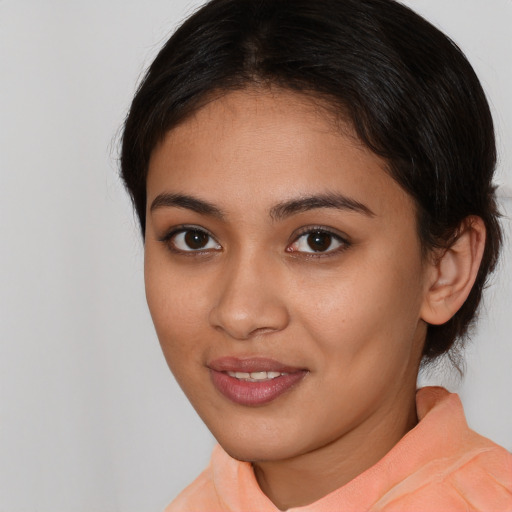 Joyful latino young-adult female with medium  brown hair and brown eyes