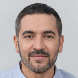 Joyful white adult male with short  black hair and brown eyes