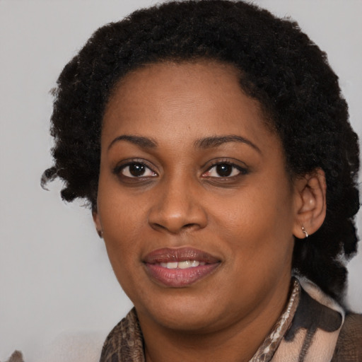 Joyful black young-adult female with long  brown hair and brown eyes
