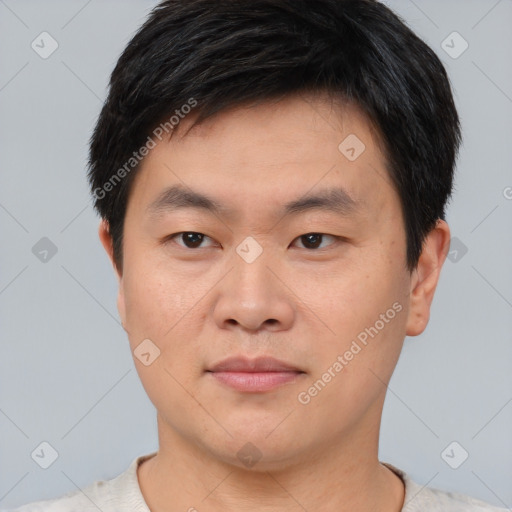 Joyful asian young-adult male with short  black hair and brown eyes