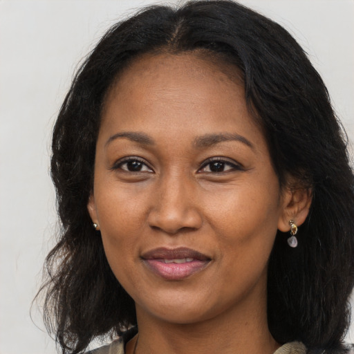 Joyful black adult female with long  brown hair and brown eyes