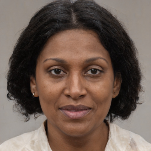 Joyful black adult female with medium  brown hair and brown eyes