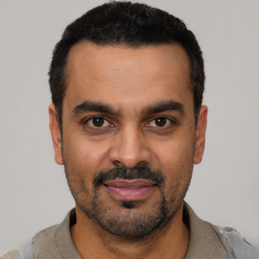 Joyful latino adult male with short  black hair and brown eyes