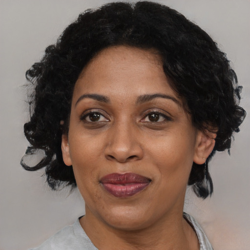 Joyful black adult female with medium  black hair and brown eyes