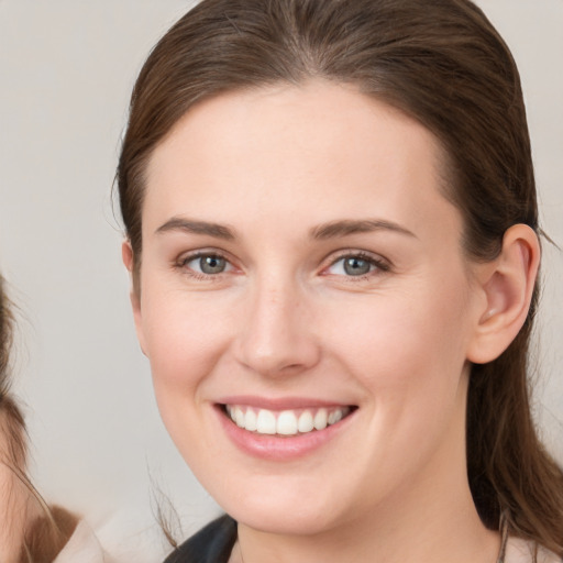 Joyful white young-adult female with medium  brown hair and blue eyes