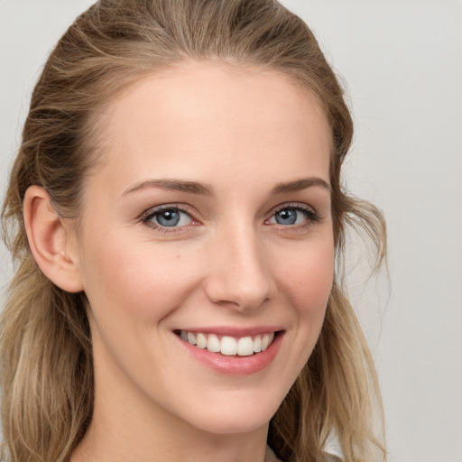 Joyful white young-adult female with long  brown hair and blue eyes