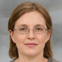 Joyful white adult female with medium  brown hair and blue eyes