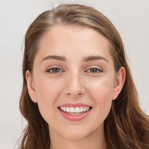 Joyful white young-adult female with long  brown hair and grey eyes