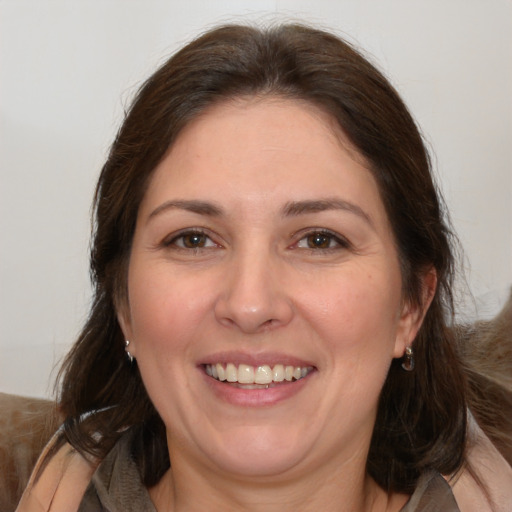 Joyful white adult female with medium  brown hair and brown eyes